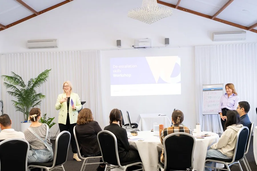 Caroline Macaulay leading a de-escalation skills workshop with a seated group